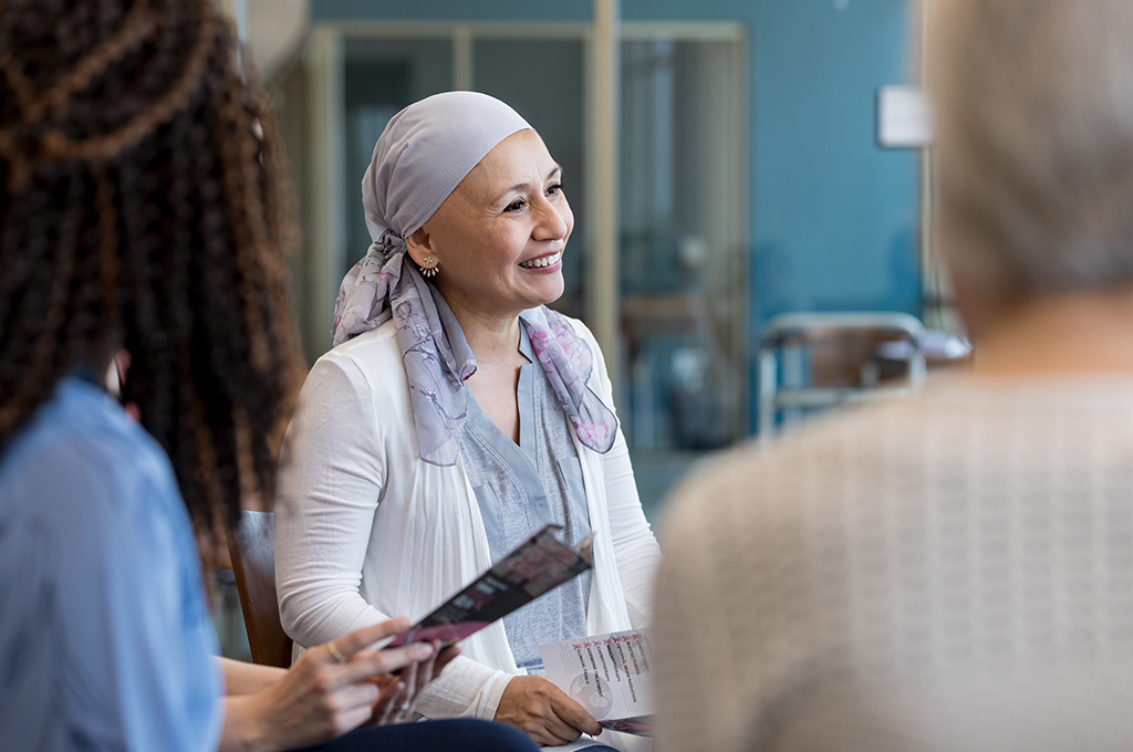 Breast cancer survivor smiles at unseen person during group therapy