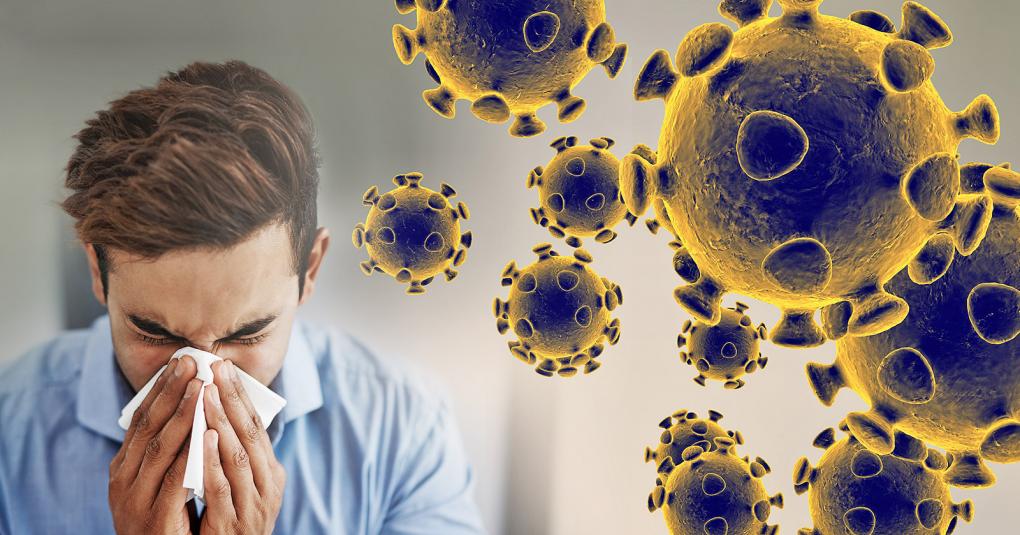 Male sneezing next to picture of the coronavirus