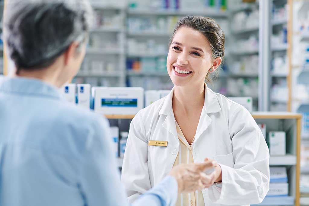 A Female Pharmacist gives assists an unidentified person