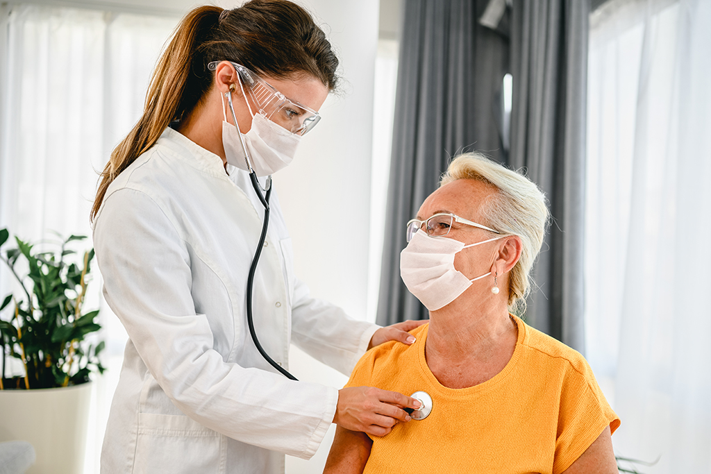 Doctor using stethoscope listening to senior patients breathing