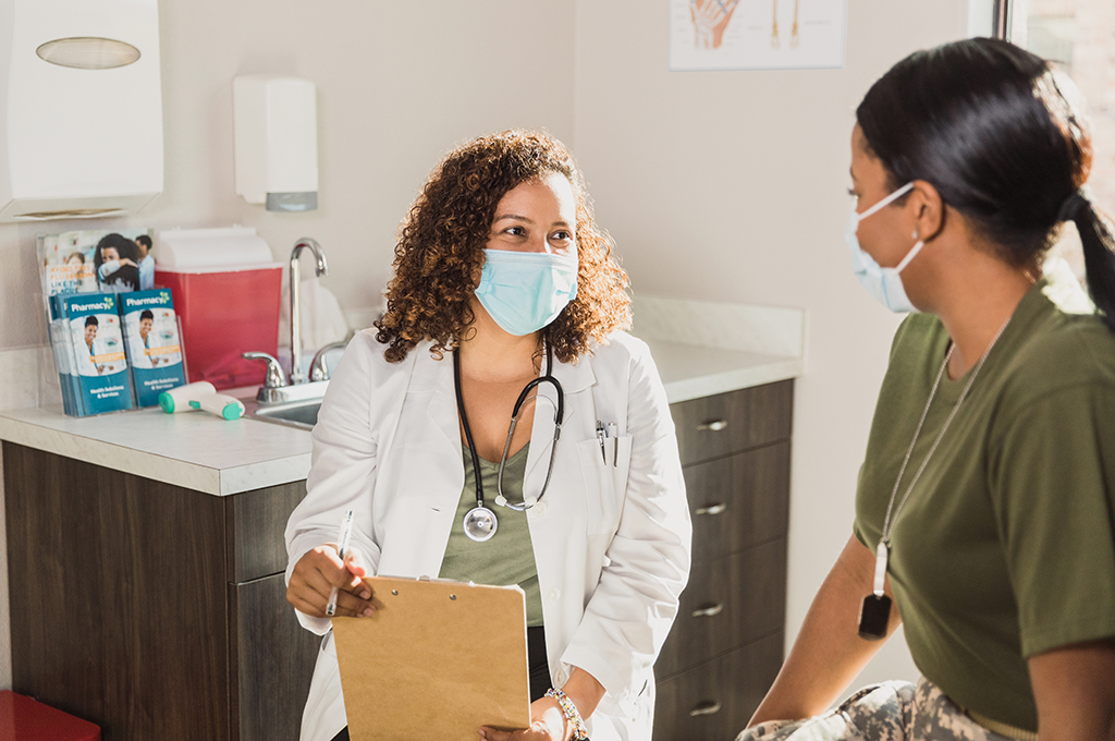 Doctor and female soldier smile through protective masks