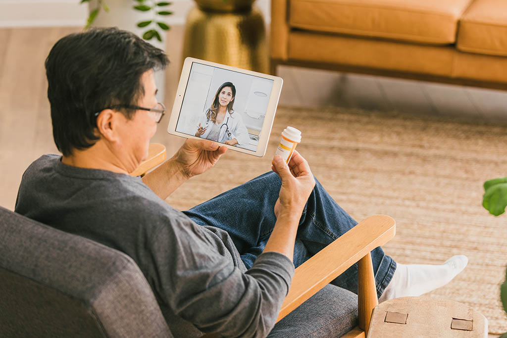 Man talks with doctor using telemedicine appointment on his tablet