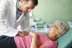 Doctor examines older woman's unbearable stomach pain