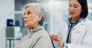 Doctor listens to patient's back with stethoscope