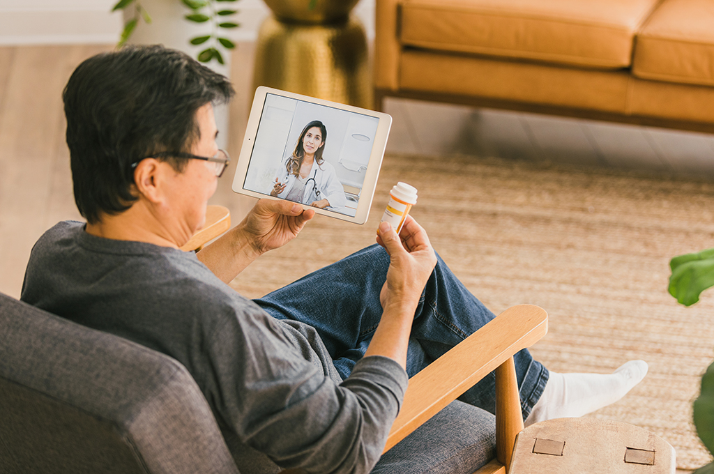 Man talks with doctor using telemedicine appointment on his tablet