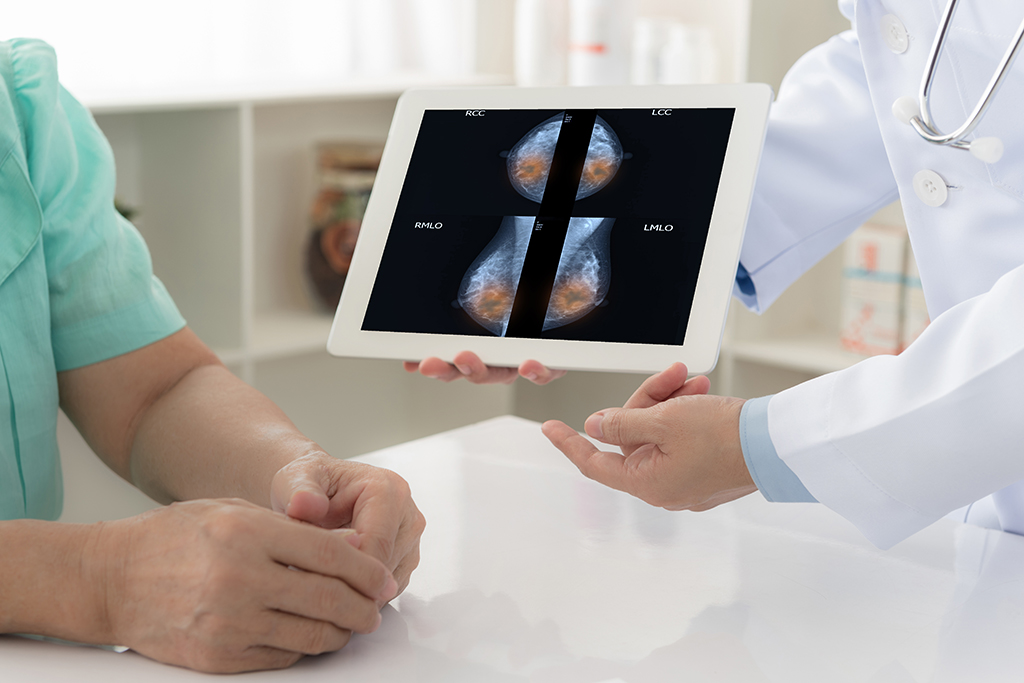 Unidentified doctor explains mammogram x-ray scan results on tablet to patient