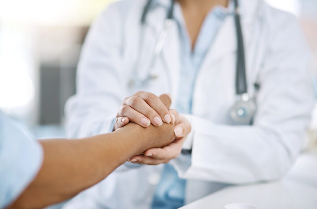 Doctor holding hand with patient