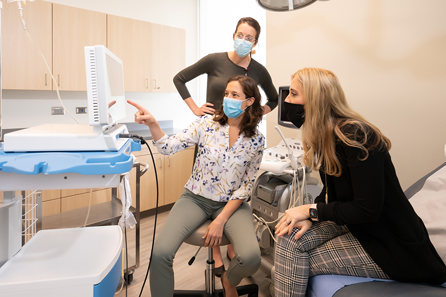 Female doctor displaying a screen to two female patients