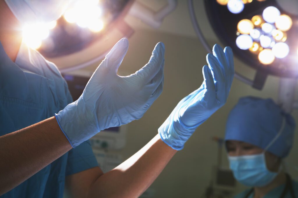 A surgeon's hands; covered by gloves