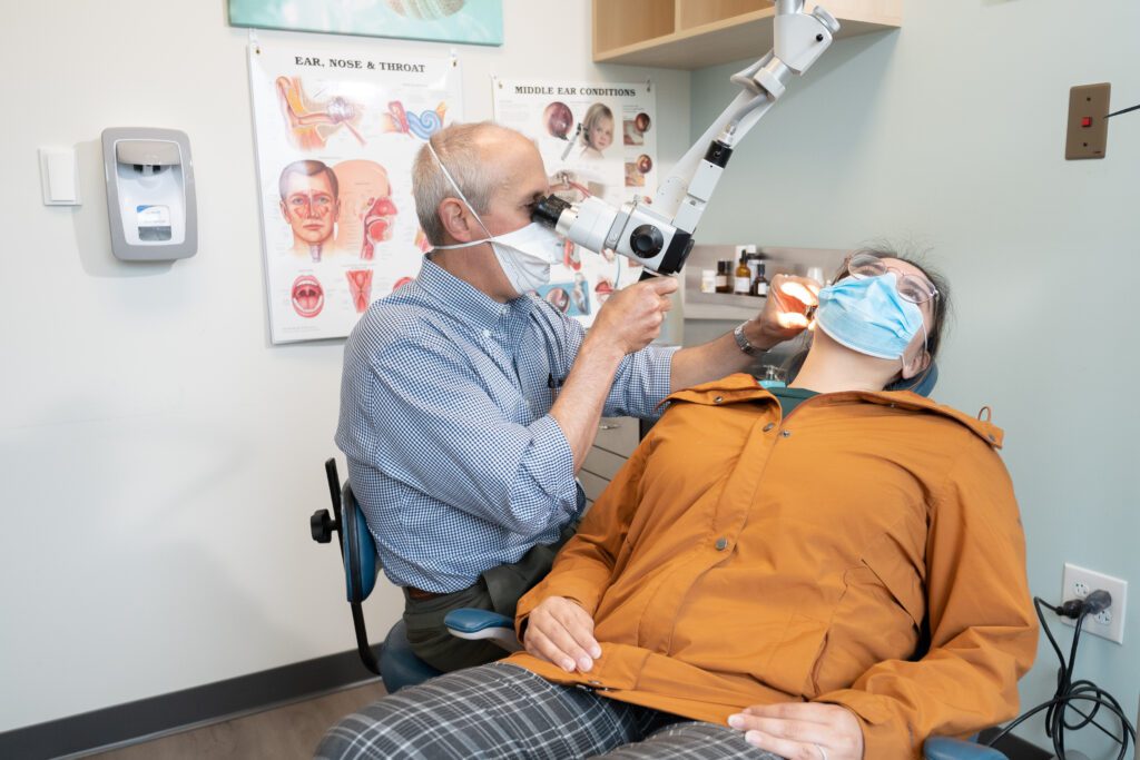Medical Professional uses a Binocular Microscopy on a patient