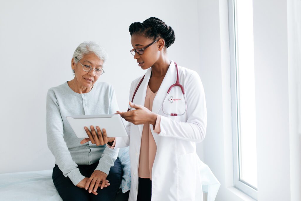 Female medical professional shows chart to older woman