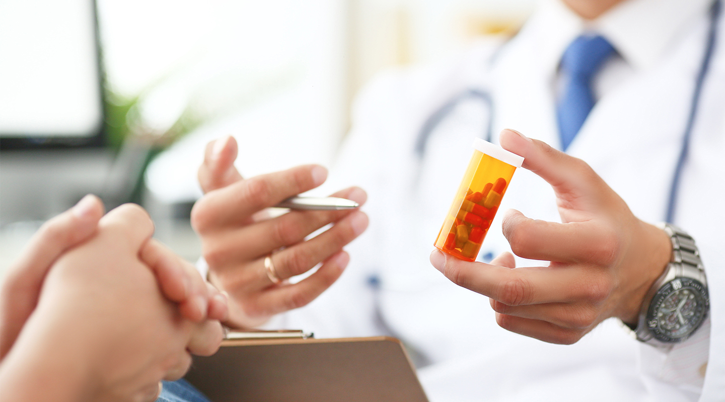 Unidentified medical professional holding pill bottle