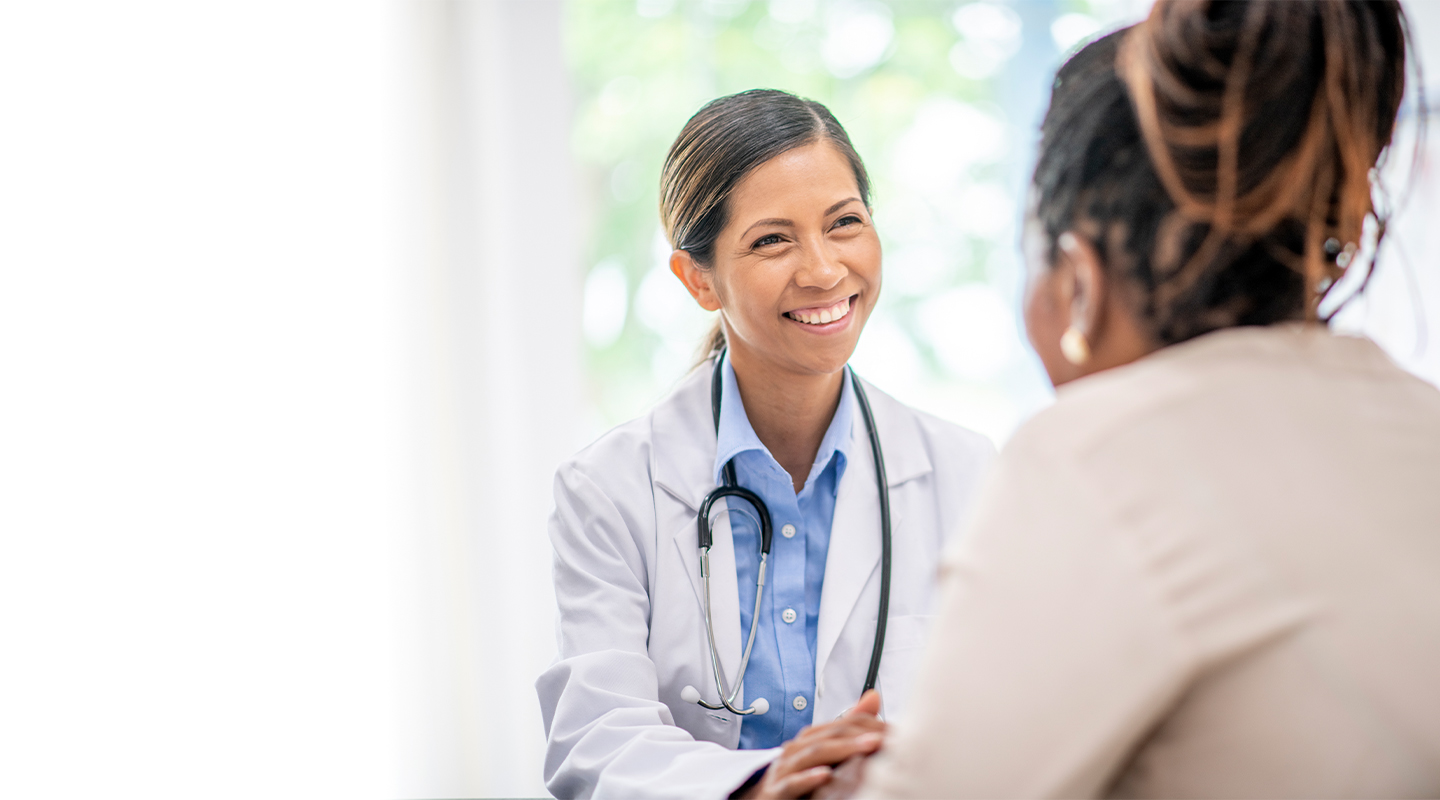 Female medical professional smiles at unidentified female patient