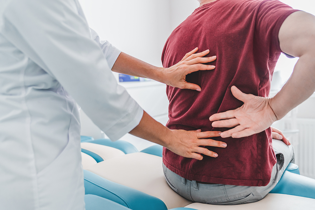 Close up of female orthopedist examining patient's back