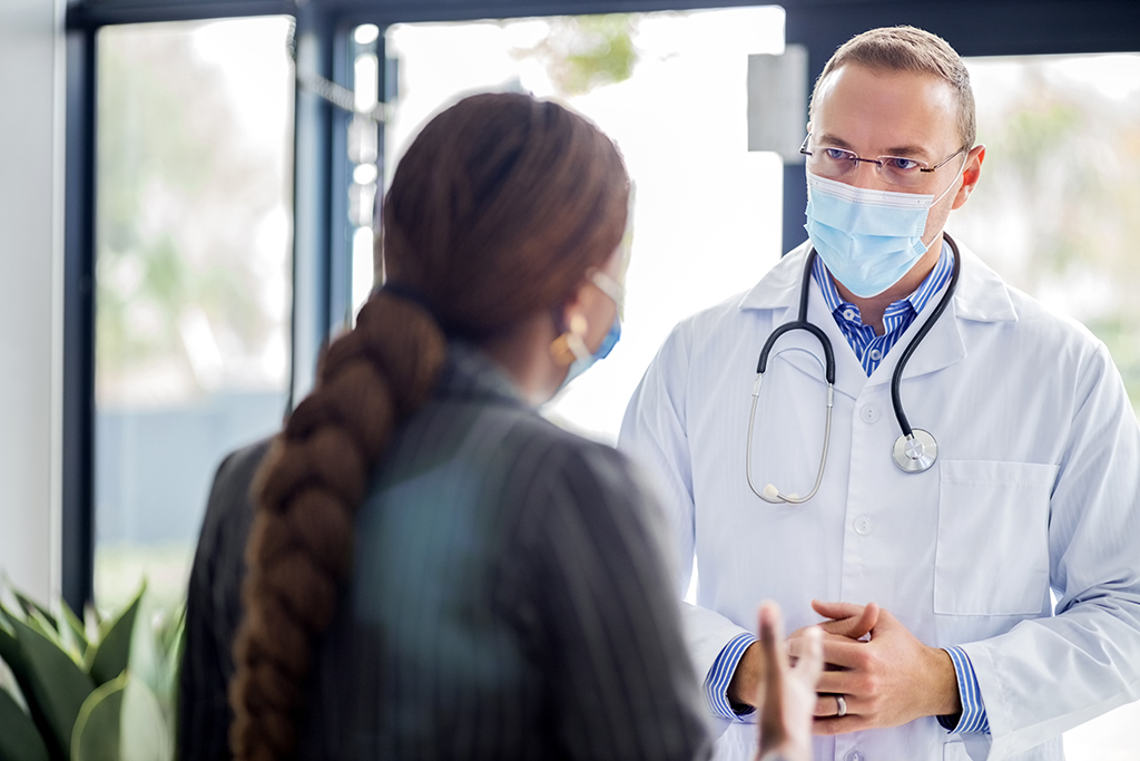 Doctor discussing with patient in hospital lobby