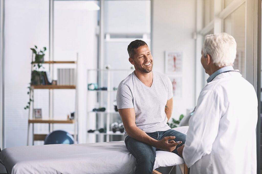 Man receiving treatment and talking with doctor