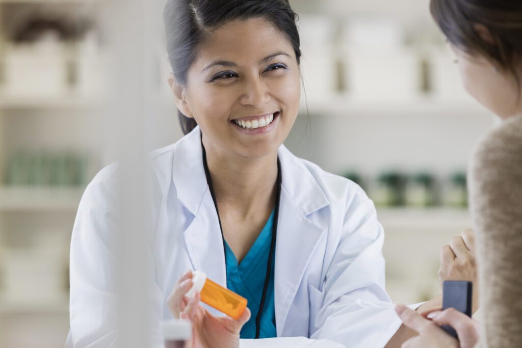 Female pharmacist speaks with a patient.