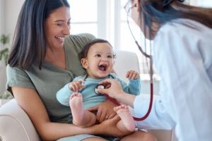 Baby laughing while receiving a checkup