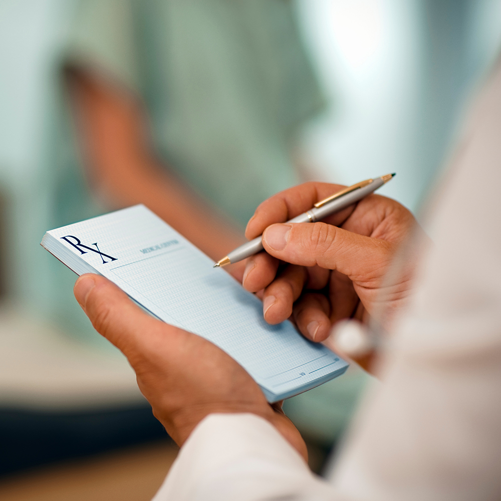 Doctor filling out RX prescription pad