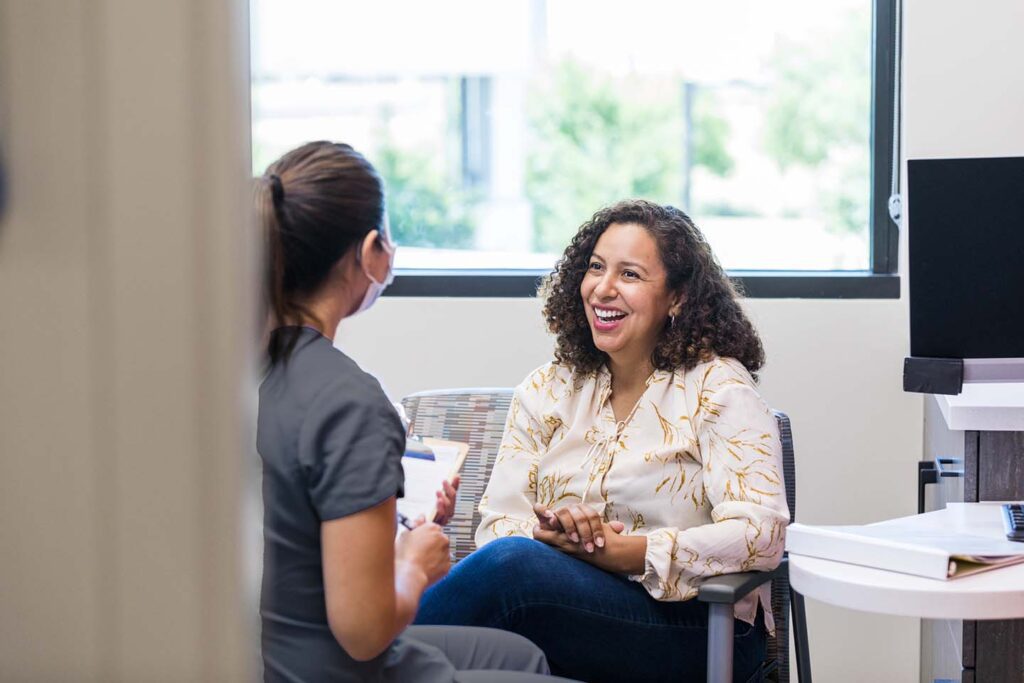 Woman smiling while speaking with healthcare provider