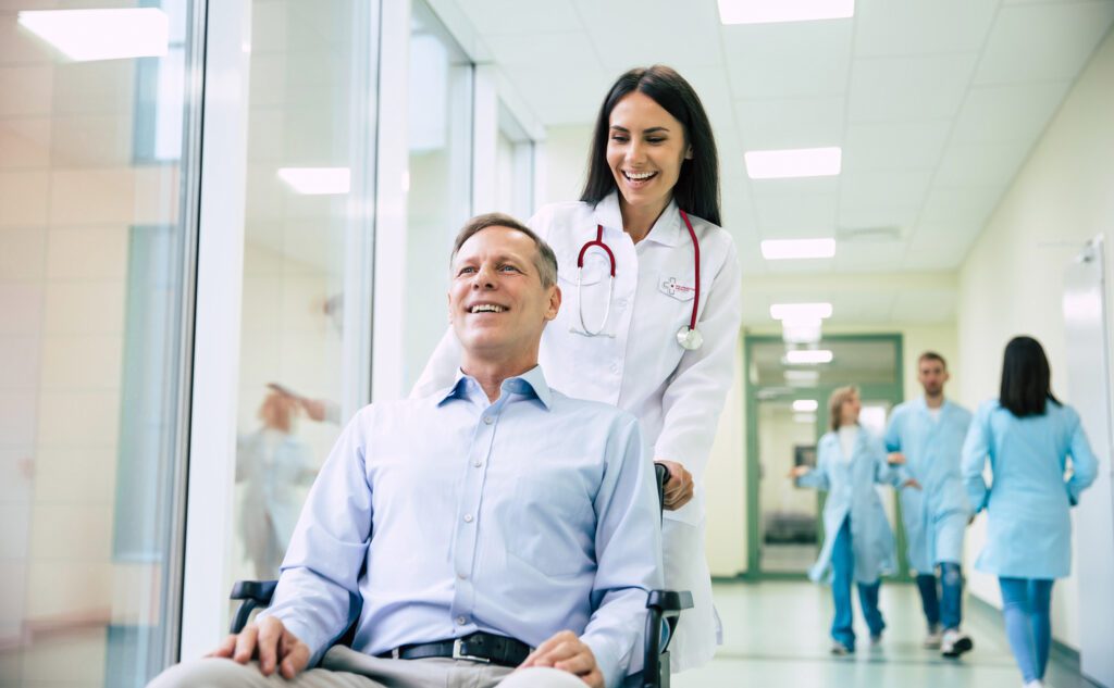 Healthcare practitioner pushing a man in a wheelchair