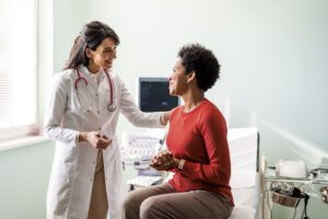 Woman smiling while speaking with her physician